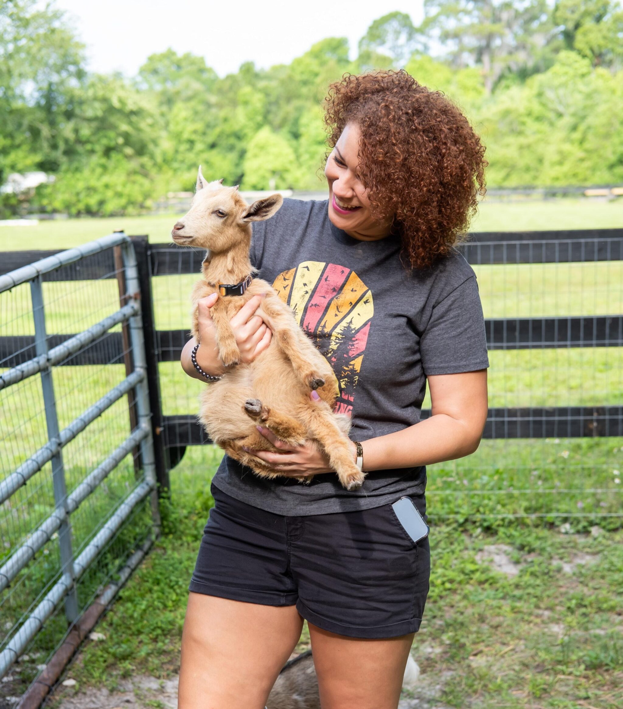 woman carrying a baby goat
