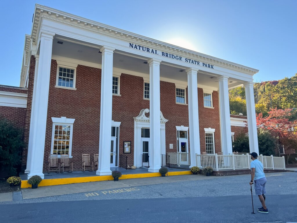 man standing in front of the natural bridge state park building