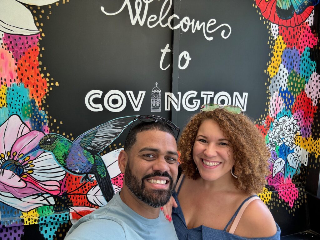 a photo of Carlos and I in the colorful Welcome to Covington mural in the Welcome Center