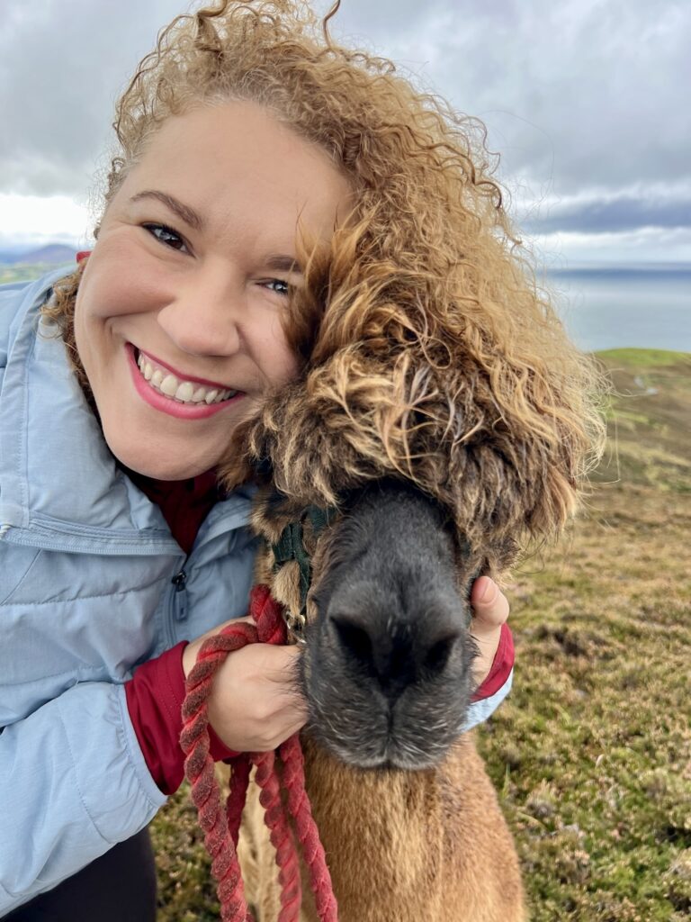Solo traveler hiking with alpaca at Wild Alpaca Way Malin Head
