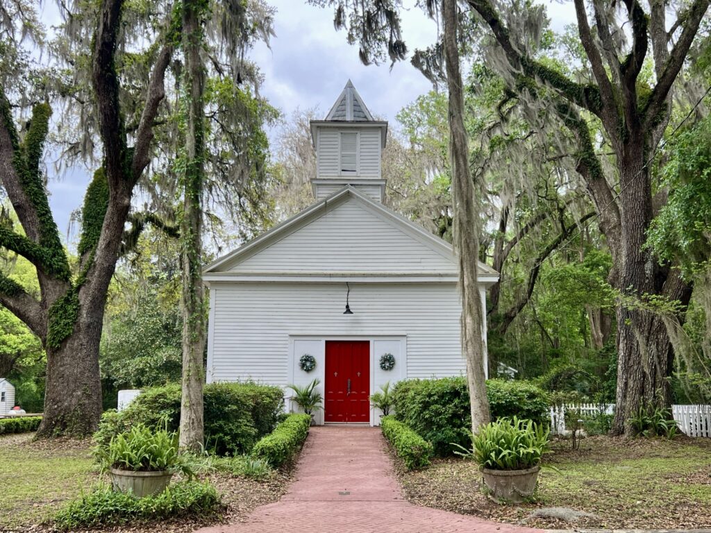 Church of the Mediator, a historic white church with red door in Micanopy