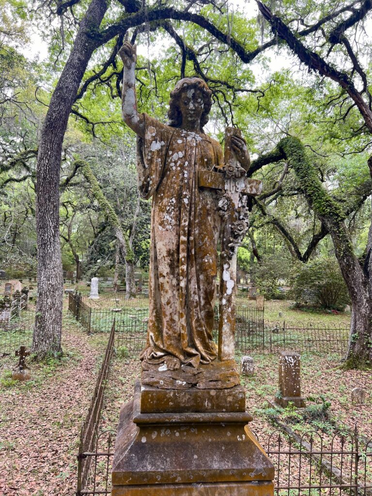 statue of woman holding a cross at the Micanopy Historic Cemetery