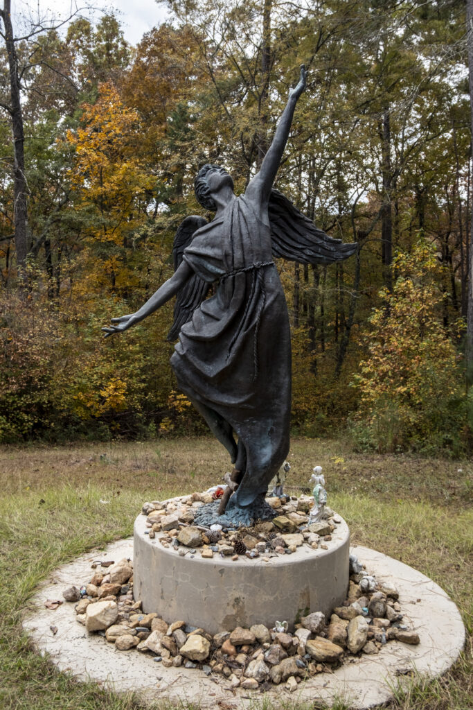 Life-size bronze guardian angel statue at Cedar Lane Cemetery at Central State Hospital, placed in 1997 as part of the restoration project to memorialize over 25,000 patients buried on the grounds.