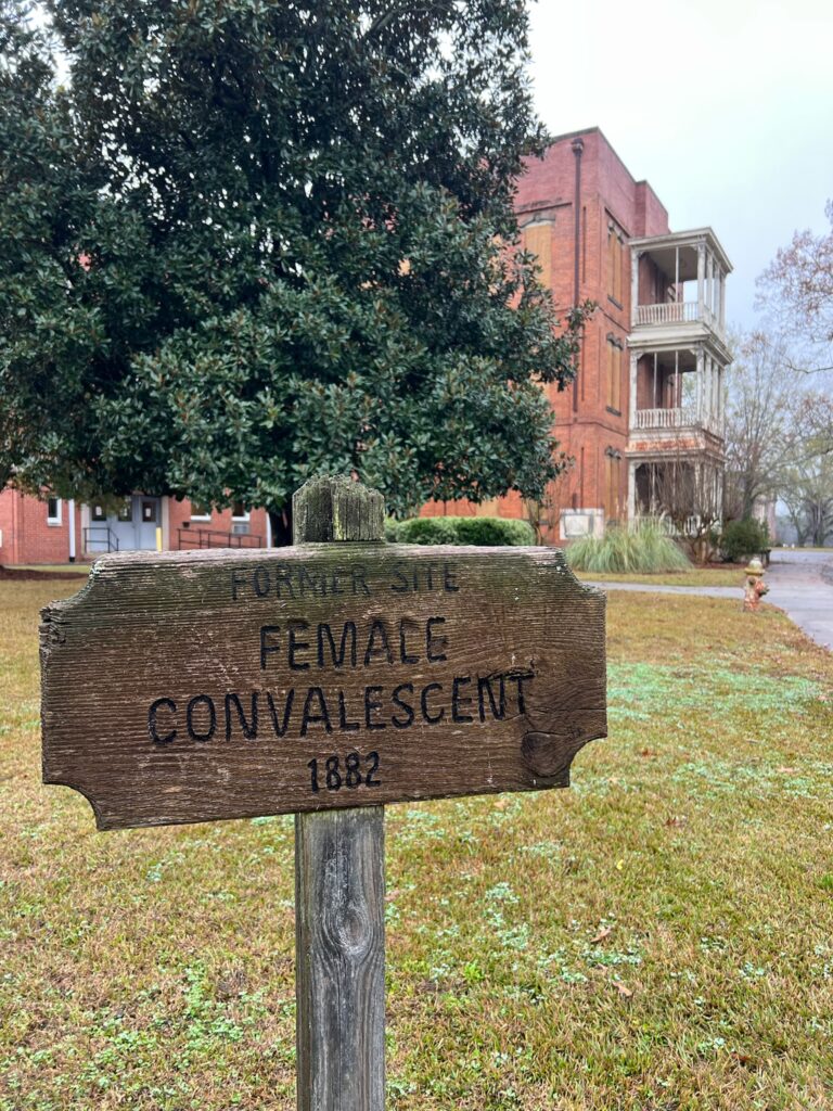 Wooden sign marking the Female Convalescent Building at Central State Hospital, one of the structures built to separate patients by gender during the hospital's expansion in the late 1800s.