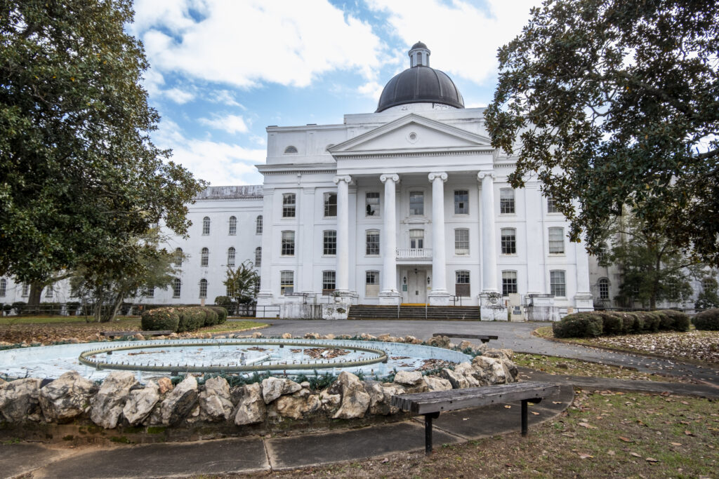 Front exterior view of the Powell Building at Central State Hospital with a former fountain in the foreground, one of the original structures dating to 1842 that served as the admissions and administrative hub for the world's largest psychiatric hospital.