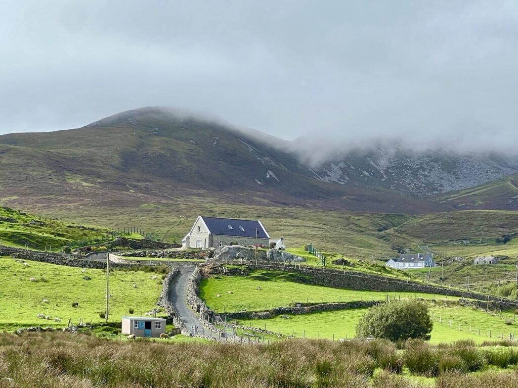 Traditional Irish cottage with misty mountains in the background in County Donegal