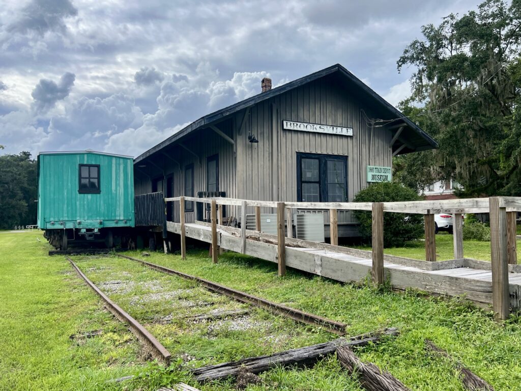The 1885 Brooksville Train Depot with the restored Cook Utility Box Car and original tracks, now a museum operated by the Hernando Historical Museum Association and starting point of the Good Neighbor Trail.